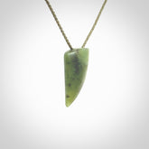 This is a lovely New Zealand Jade, pounamu niho drop pendant. It is bound with an adjustable khaki coloured cord which is length adjustable.
